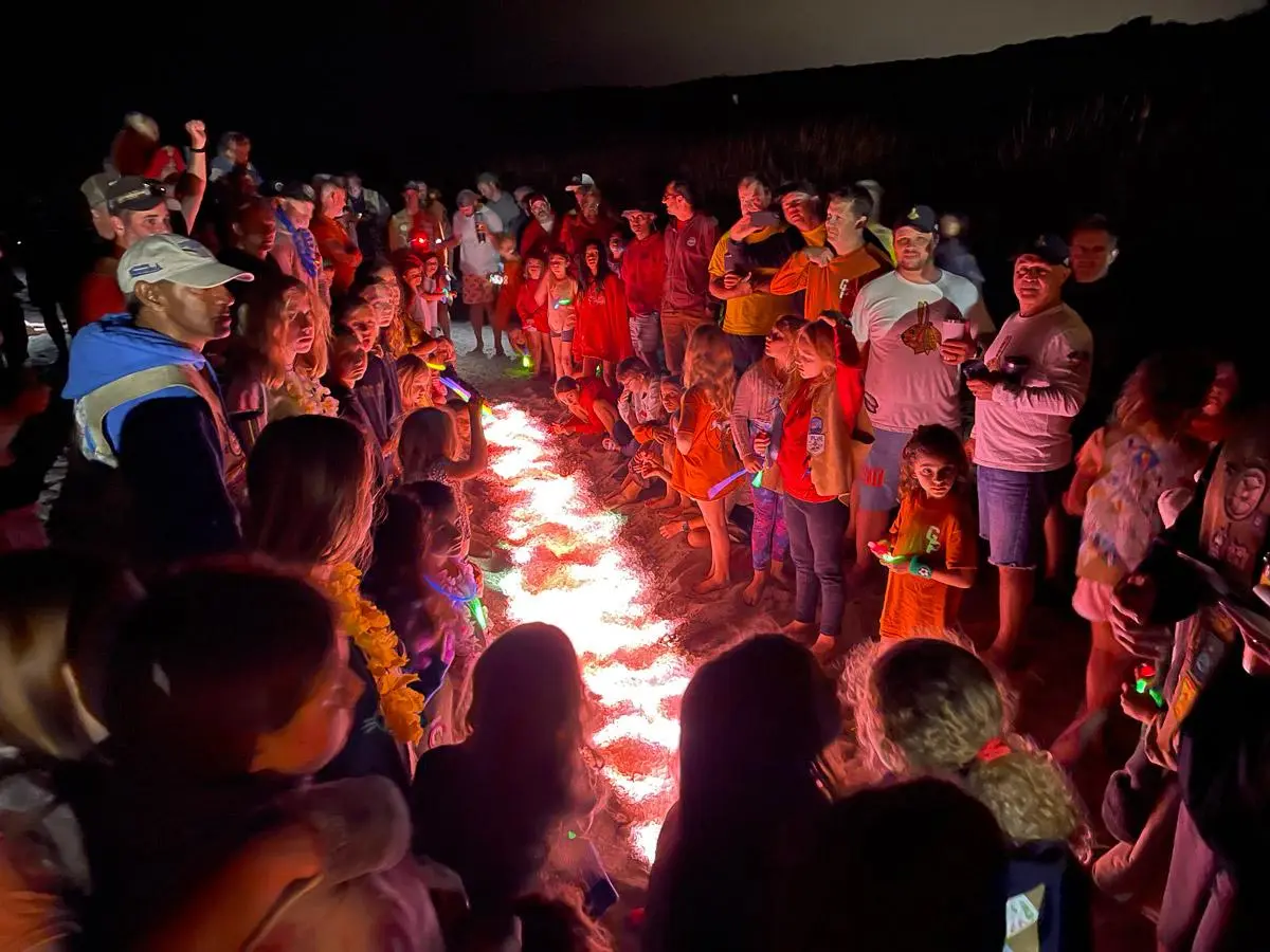 Wildcat families gathered around a glowing club fire